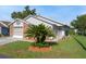 Charming single-story home featuring a well-manicured lawn and tropical landscaping, creating a welcoming curb appeal at 37420 Teaberry Loop, Zephyrhills, FL 33542