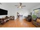Spacious living room featuring hardwood floors, a ceiling fan, and plenty of natural light at 37420 Teaberry Loop, Zephyrhills, FL 33542