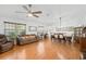 Open concept living room features hardwood floors, neutral paint and is filled with natural light from large windows at 37420 Teaberry Loop, Zephyrhills, FL 33542