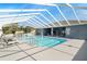 The community pool has an expansive screened area and features many chairs and tables at 37420 Teaberry Loop, Zephyrhills, FL 33542