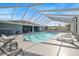 Inviting community pool under a covered enclosure, surrounded by ample seating and sun loungers at 37420 Teaberry Loop, Zephyrhills, FL 33542