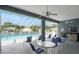 Inviting pool area with tables and chairs, offering a comfortable space for relaxation and socializing at 37420 Teaberry Loop, Zephyrhills, FL 33542