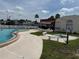 Relaxing community pool area with comfortable seating on a bright, sunny day at 37832 Madeira Ave, Zephyrhills, FL 33541