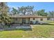 View of backyard with mature trees, screened patio and partially bricked area at 4221 Burrows Rd, Zephyrhills, FL 33542