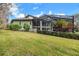 A serene backyard with a well maintained lawn, mature landscaping, and a screened in patio at 4641 John Moore Rd, Brandon, FL 33511