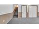 Finished basement with stairs, gray carpet, wood trim, and access to additional rooms at 4641 John Moore Rd, Brandon, FL 33511