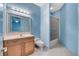 Blue bathroom with light wood vanity, shower-tub combination, and modern fixtures at 4641 John Moore Rd, Brandon, FL 33511