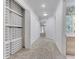 Long hallway featuring built in shelving, carpeted floors and view to bathroom at the end at 4641 John Moore Rd, Brandon, FL 33511