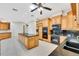 Bright kitchen with stone countertops, light wood cabinets and black appliances at 4641 John Moore Rd, Brandon, FL 33511