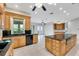 Large kitchen featuring granite countertops, an island, wood cabinets and tile flooring at 4641 John Moore Rd, Brandon, FL 33511