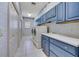 Spacious laundry room with blue cabinets, white countertops, washer and dryer, and tile flooring at 4641 John Moore Rd, Brandon, FL 33511