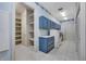 Large laundry room featuring blue cabinets, a utility sink, shelving, and tiled floors at 4641 John Moore Rd, Brandon, FL 33511