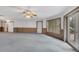 Cozy living room with gray carpet, wood trim, lots of windows, and access to another room at 4641 John Moore Rd, Brandon, FL 33511