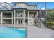 Back of house features balconies and stairs leading to pool, all enclosed with black metal screen at 4641 John Moore Rd, Brandon, FL 33511