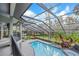 A beautiful pool is surrounded by lush landscaping and an enclosure at 4641 John Moore Rd, Brandon, FL 33511