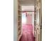 Bright bedroom features classic floral wallpaper, plush pink carpet, and built-in closet shelving at 502 Chilt Dr, Brandon, FL 33510