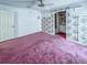 Bright bedroom with floral wallpaper, pink carpet, ceiling fan, and an attached bathroom at 502 Chilt Dr, Brandon, FL 33510