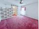 Bright bedroom with floral wallpaper, pink carpet, ceiling fan, and an attached bathroom at 502 Chilt Dr, Brandon, FL 33510