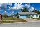 Charming home with light blue accents, a front yard and attached garage under a partly cloudy sky at 502 Chilt Dr, Brandon, FL 33510