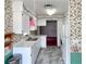 Galley kitchen with white cabinets, grey and white flooring, and floral patterned wallpaper at 502 Chilt Dr, Brandon, FL 33510