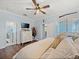 Bedroom with dresser, TV, en-suite bathroom, and wood floors at 574 Bimini Bay Blvd, Apollo Beach, FL 33572