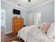 Comfortable bedroom with wood floors, dresser, and TV at 574 Bimini Bay Blvd, Apollo Beach, FL 33572