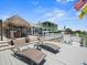 Upper deck with lounge chairs overlooking pool, Tiki hut, and waterway views at 574 Bimini Bay Blvd, Apollo Beach, FL 33572