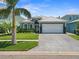 Charming single-story home with lush lawn, a paver driveway, two-car garage and well-maintained landscaping at 574 Bimini Bay Blvd, Apollo Beach, FL 33572