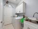 Bright laundry room equipped with washer, dryer, sink, and ample storage cabinets, providing convenience and organization at 574 Bimini Bay Blvd, Apollo Beach, FL 33572
