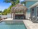 Outdoor pool featuring a tiki hut, outdoor kitchen, and lounge area at 574 Bimini Bay Blvd, Apollo Beach, FL 33572