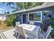 Backyard patio area with a table, chairs, plants, and the exterior of the blue house at 5947 46Th N Ave, Kenneth City, FL 33709
