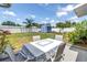 Backyard patio area with a table, chairs and a shed in a fenced backyard under a blue sky at 5947 46Th N Ave, Kenneth City, FL 33709