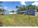View of the home's fenced backyard with blue shed and outdoor patio area with table and chairs at 5947 46Th N Ave, Kenneth City, FL 33709