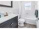 Bright bathroom featuring a vanity with a dark cabinet, tub and shower combination and tiled walls at 5947 46Th N Ave, Kenneth City, FL 33709