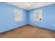 Bedroom with light blue walls, brown carpet and two windows with white blinds at 5947 46Th N Ave, Kenneth City, FL 33709