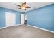 This blue bedroom features plush carpet, ceiling fan, and closet for storage space at 5947 46Th N Ave, Kenneth City, FL 33709