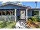 A charming home exterior featuring a cozy front porch with decorative columns and vibrant landscaping at 5947 46Th N Ave, Kenneth City, FL 33709