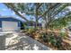 Charming blue single-story home showcasing a large tree-covered front yard and a welcoming driveway at 5947 46Th N Ave, Kenneth City, FL 33709