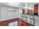 Open-concept living area with hardwood floors, featuring a breakfast bar with seating and kitchen view at 5947 46Th N Ave, Kenneth City, FL 33709