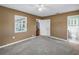 Neutral bedroom has carpet, ceiling fan, two windows, and attached ensuite bathroom at 5947 46Th N Ave, Kenneth City, FL 33709