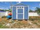 Blue backyard shed with white trim and a door and a kayak rack with kayaks at 5947 46Th N Ave, Kenneth City, FL 33709