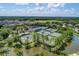 Aerial view of the community amenities including a clubhouse, tennis courts, and a large pond at 6127 Cezanne Ave, Lutz, FL 33558