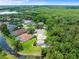 Aerial view of a residence with a lush backdrop, pond, screened-in patio, and cul-de-sac in a desirable community at 6127 Cezanne Ave, Lutz, FL 33558