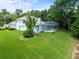 Spacious backyard featuring an enclosed pool with screened enclosure surrounded by lush greenery at 6127 Cezanne Ave, Lutz, FL 33558