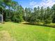 Spacious backyard featuring green grass, pond and privacy landscaping at 6127 Cezanne Ave, Lutz, FL 33558