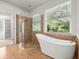 Bathroom with freestanding tub, glass enclosed shower, and tile floors at 6127 Cezanne Ave, Lutz, FL 33558