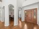 Elegant foyer with hardwood floors, high ceilings, and an arched entry leading to the dining room for refined living at 6127 Cezanne Ave, Lutz, FL 33558