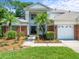 Beautiful two-story home with brick accents, manicured landscaping, palm trees, and a spacious three-car garage at 6127 Cezanne Ave, Lutz, FL 33558