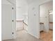 Upstairs hallway with neutral carpet, wooden banister and access to the bathroom provides natural light at 6127 Cezanne Ave, Lutz, FL 33558