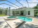 Beautiful, screened-in pool and spa with view of the home's exterior at 6127 Cezanne Ave, Lutz, FL 33558